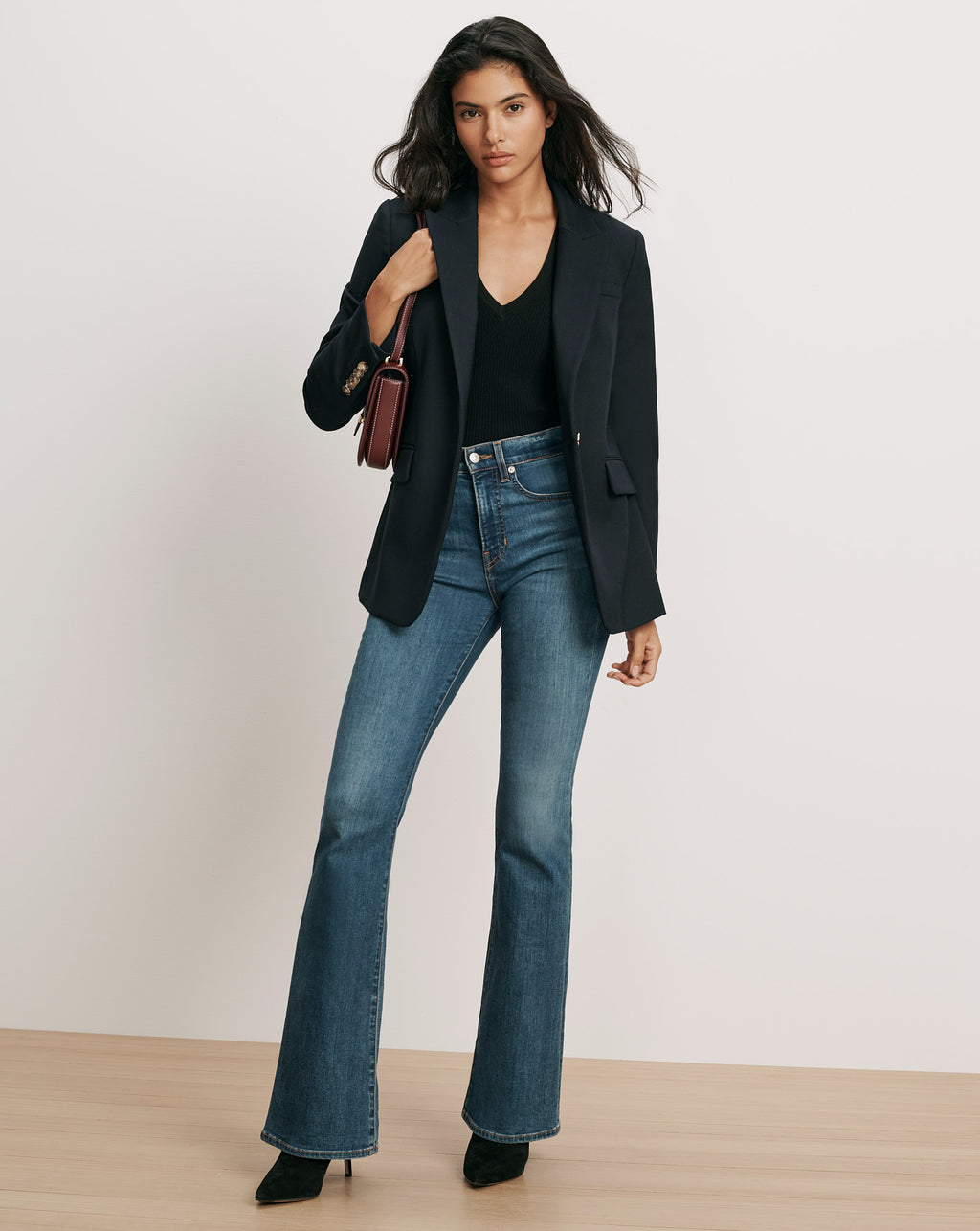 Veronica Beard Navy blazer, black top, blue flare jeans.