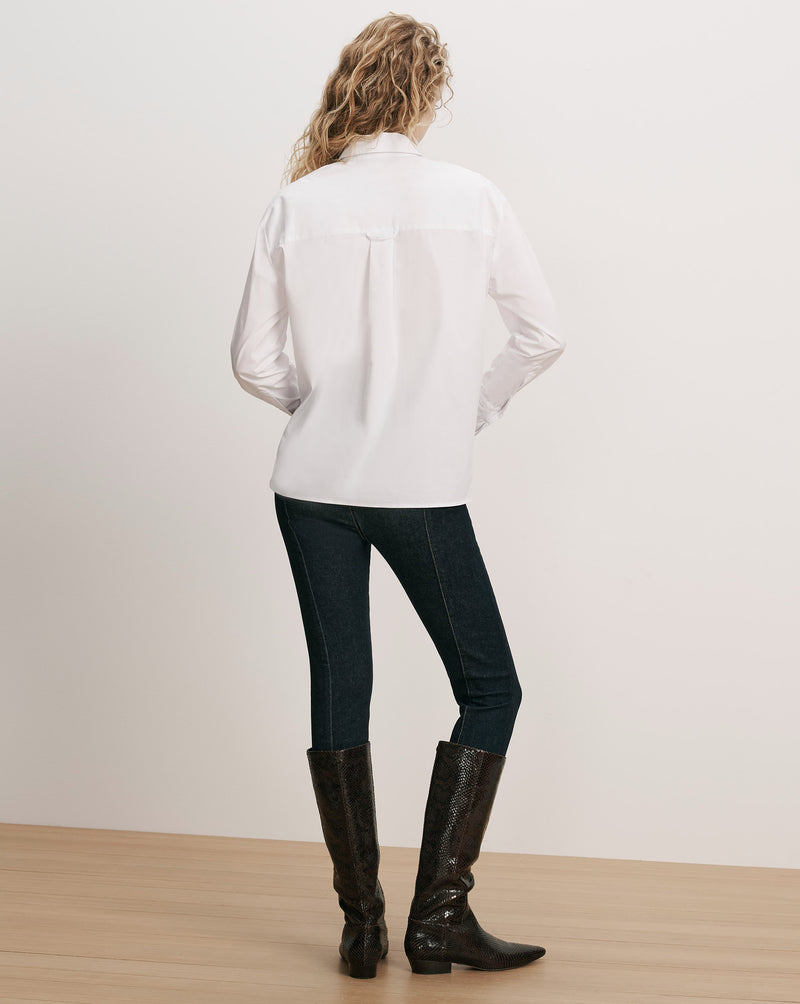 Veronica Beard White cotton button-up shirt, dark wash jeans, brown boots.