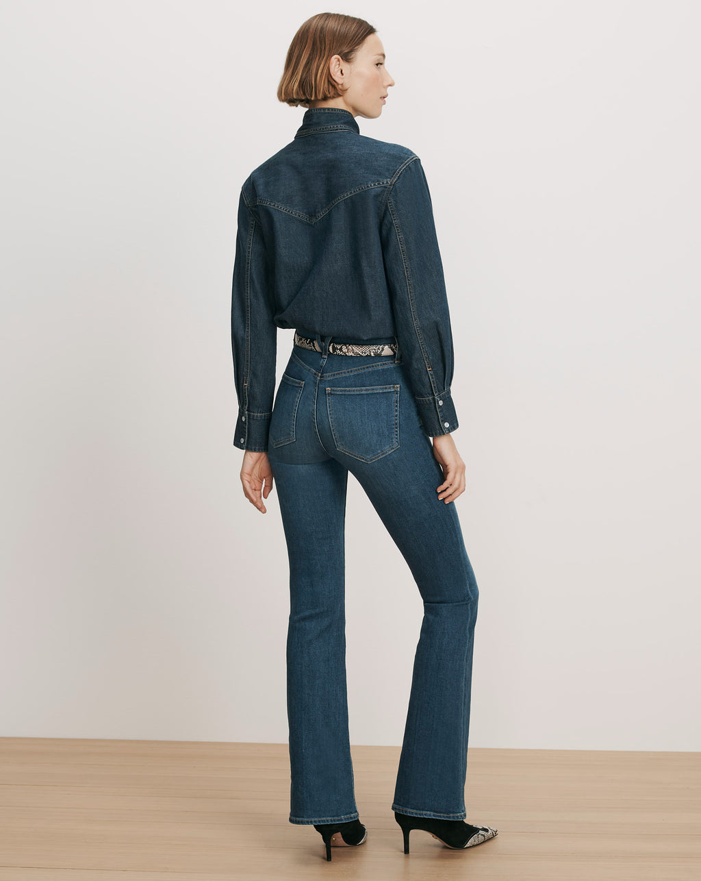 Veronica Beard Denim shirt and flared jeans with a patterned belt.