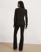 Veronica Beard Dark green long-sleeve sweater and patterned black pants.
