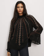 Veronica Beard Black sheer blouse with intricate red embroidery.
