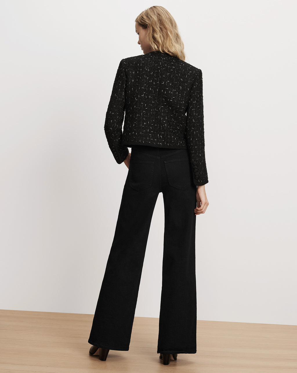 Veronica Beard Black tweed jacket and black wide-leg jeans.