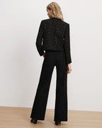 Veronica Beard Black tweed jacket and black wide-leg jeans.