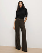 Veronica Beard Black ribbed turtleneck and dark brown wide trousers.