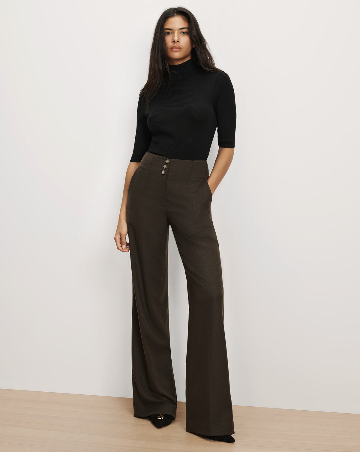 Veronica Beard Black ribbed turtleneck and dark brown wide trousers.
