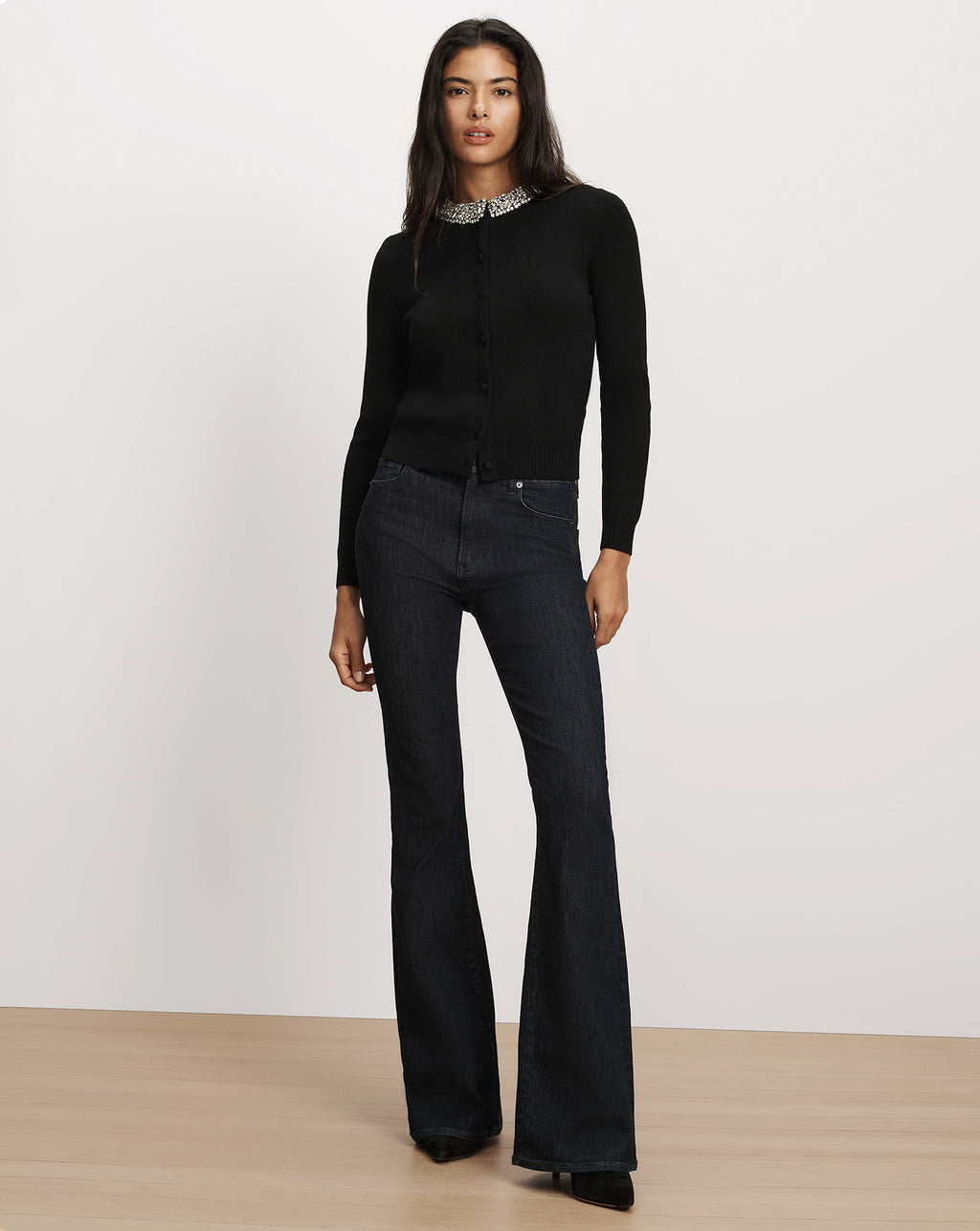 Veronica Beard Black cardigan and dark flare jeans.