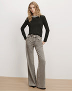 Veronica Beard Black embellished sweater and grey wide-leg jeans.