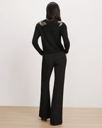 Veronica Beard Black sweater with embroidered shoulders and black trousers.