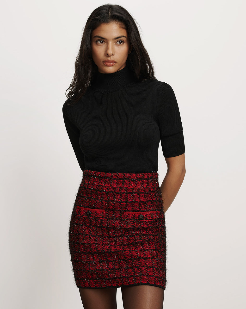 Veronica Beard Black turtleneck sweater and red tweed miniskirt.