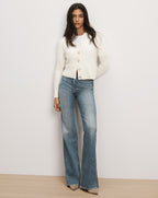 Veronica Beard White knit button-up cardigan and blue jeans.