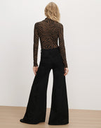 Veronica Beard Brown zebra print turtleneck and black flared trousers.