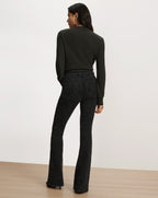 Veronica Beard Black patterned flare jeans and dark green sweater.