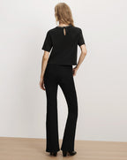 Veronica Beard Black short-sleeve top and flared jeans.