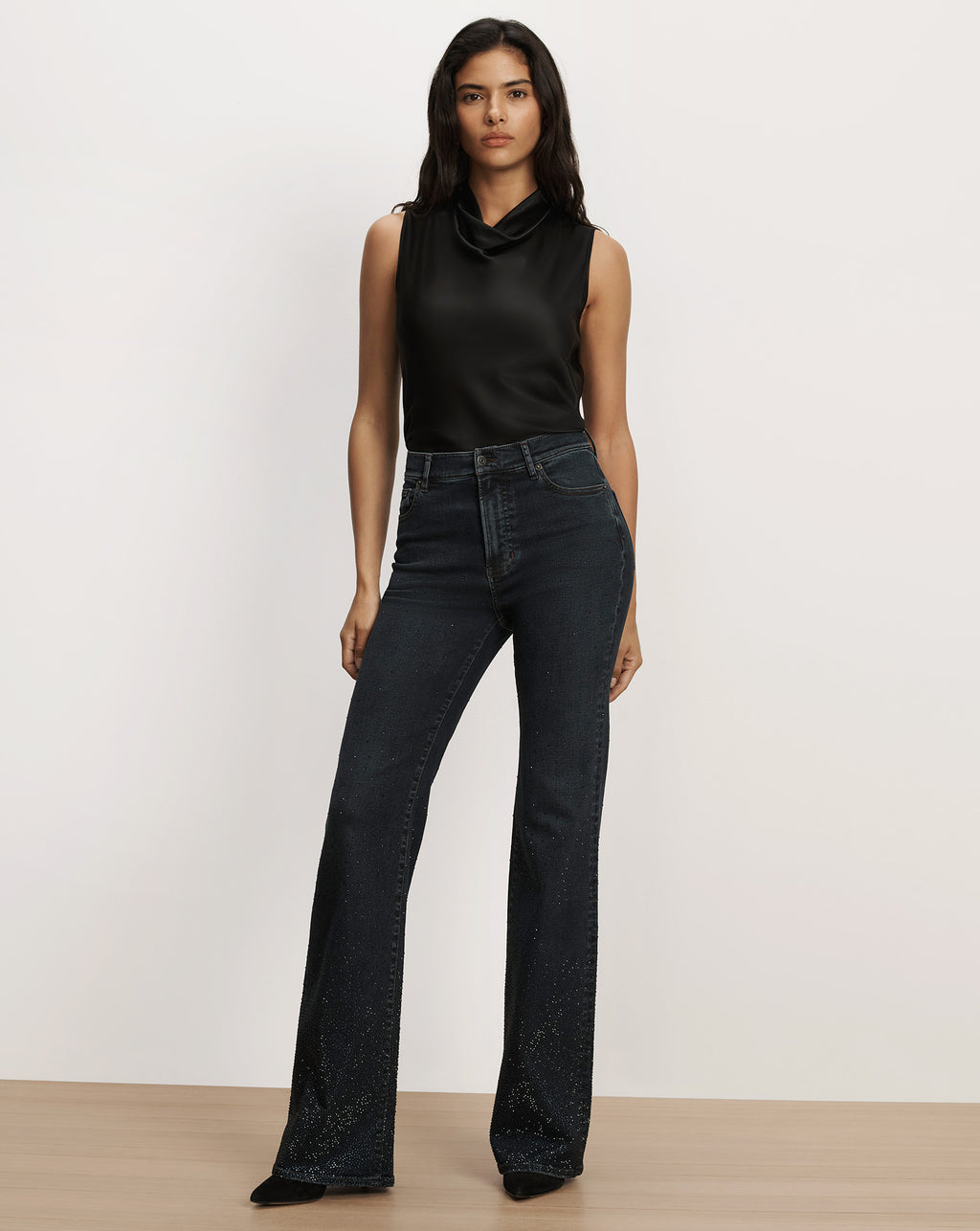 Veronica Beard Black sleeveless satin top and dark denim jeans.