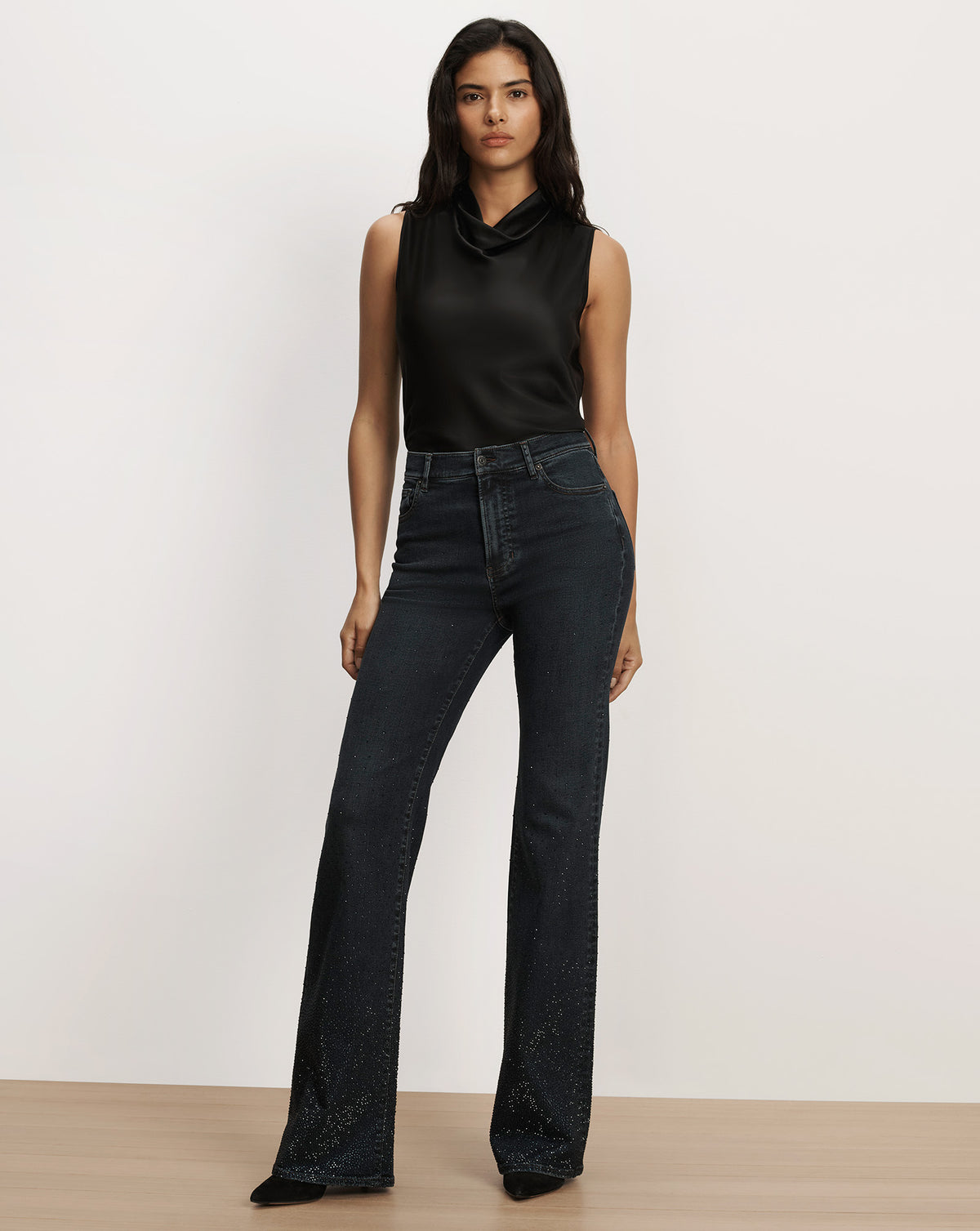 Veronica Beard Black sleeveless satin top and dark denim jeans.