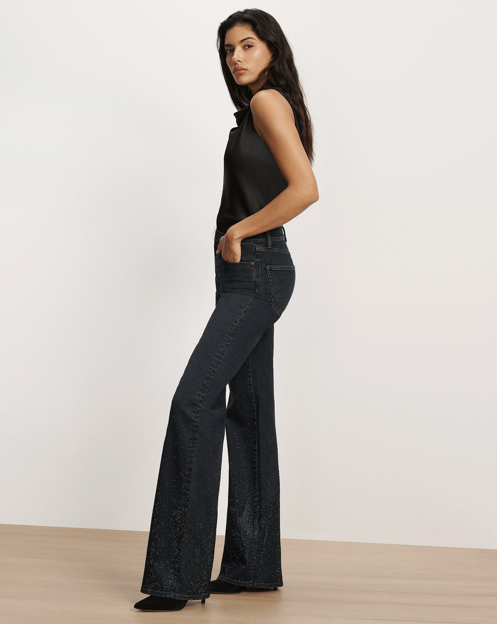Veronica Beard Black sleeveless top and embellished flare jeans.