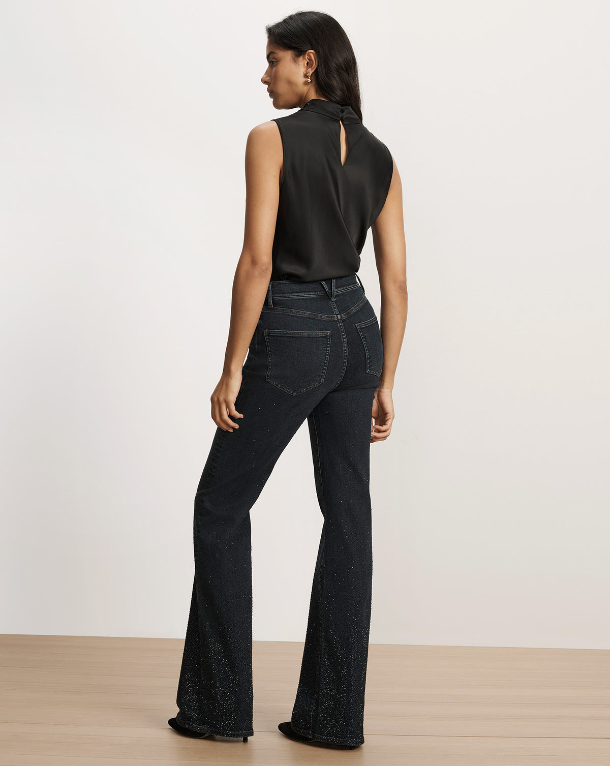 Veronica Beard Black sleeveless top and embellished flare jeans.