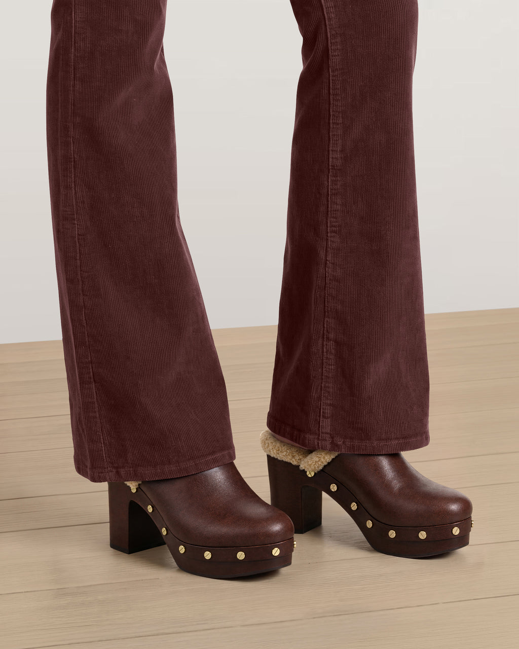 Veronica Beard Burgundy corduroy flared trousers and brown clogs.