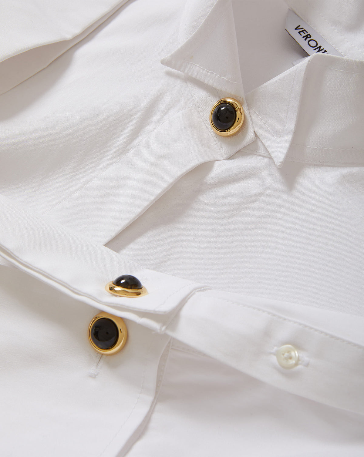 Veronica Beard White shirt with gold and black buttons.