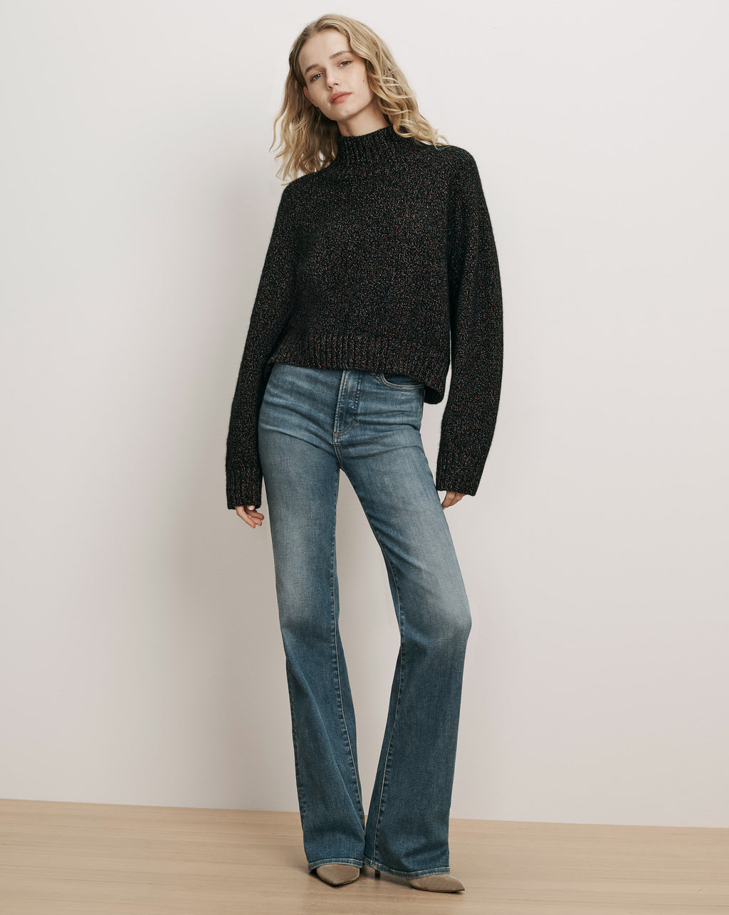 Veronica Beard Black speckled mock neck sweater, blue flare jeans.