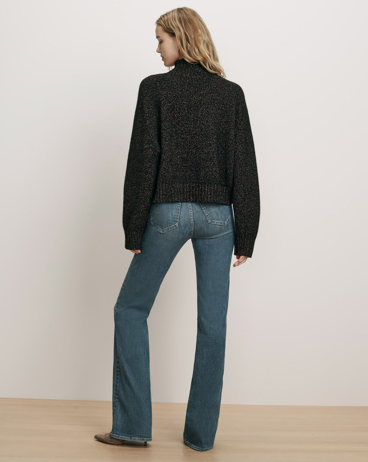 Veronica Beard Black knit sweater and blue jeans.