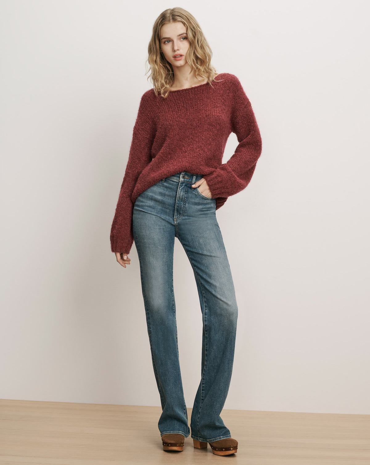 Veronica Beard Burgundy knit sweater and blue denim jeans.