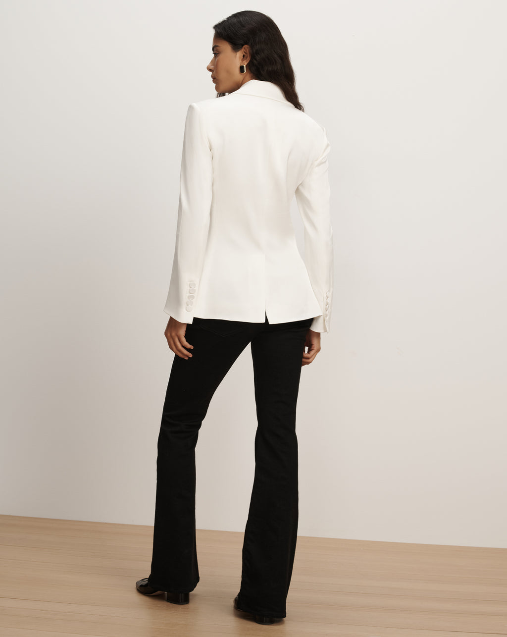 Veronica Beard White tailored blazer and black flared trousers.