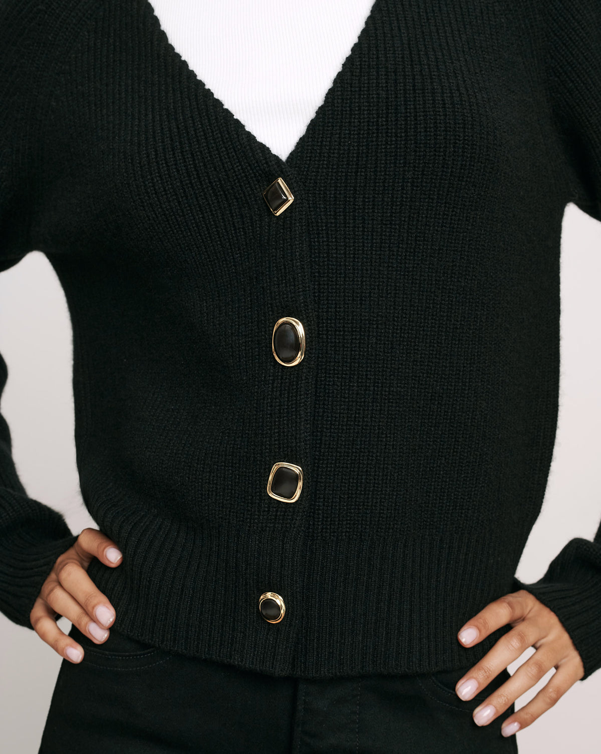 Veronica Beard Black knit cardigan with ornate gold-rimmed buttons.