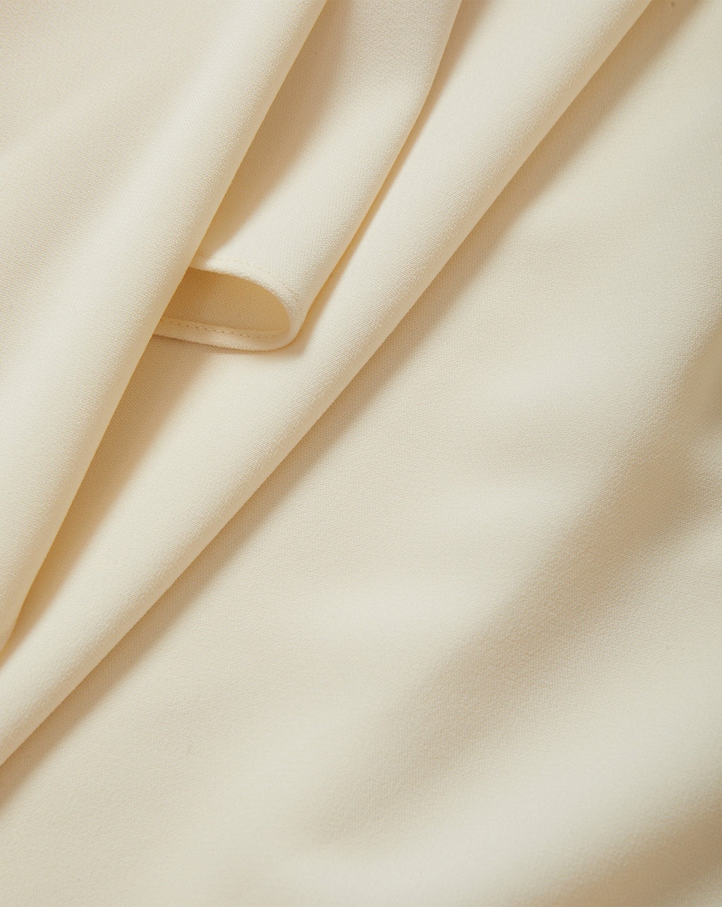 Veronica Beard Cream crepe fabric with soft draping folds.