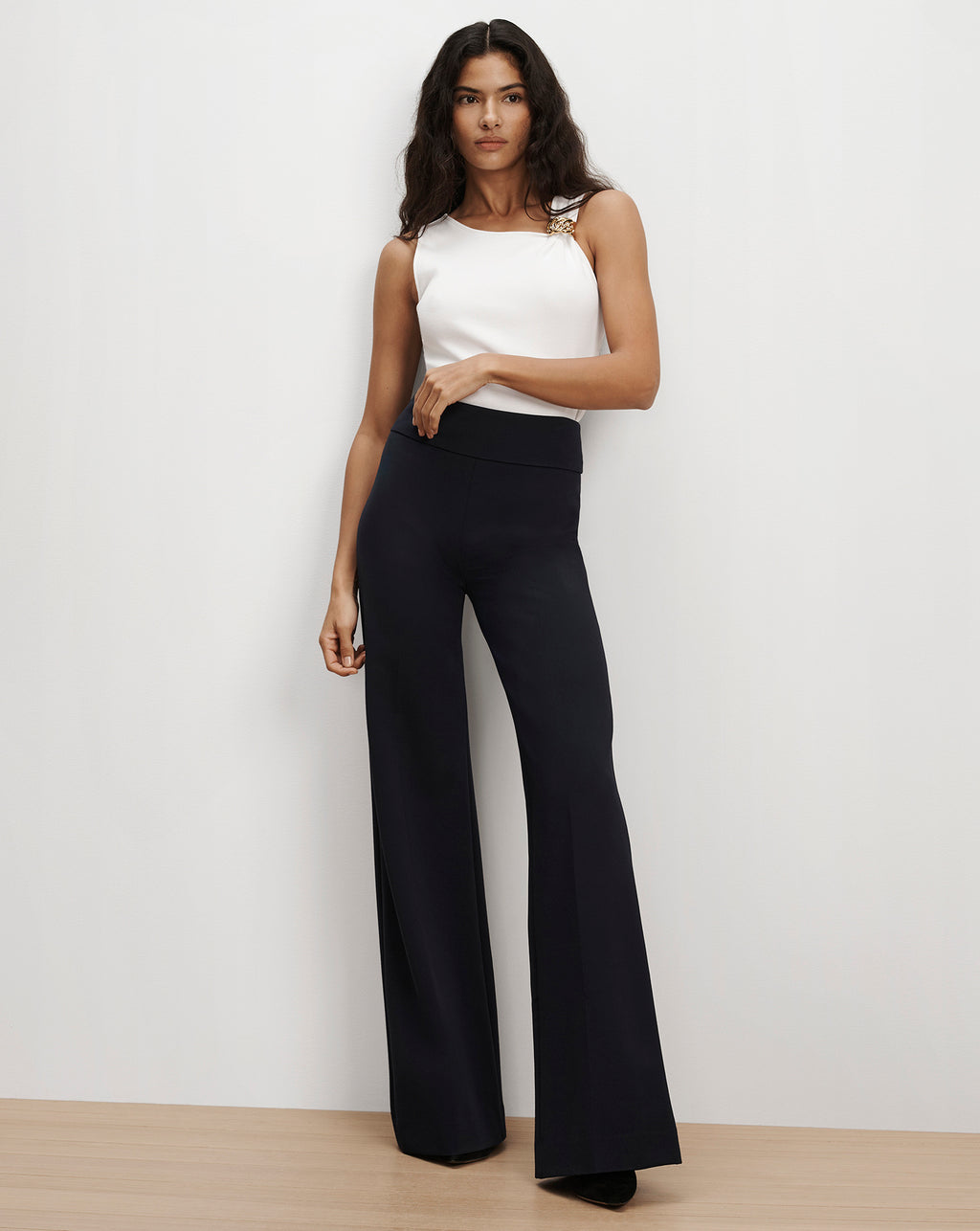 Veronica Beard Black high-waisted wide-leg trousers and white top.