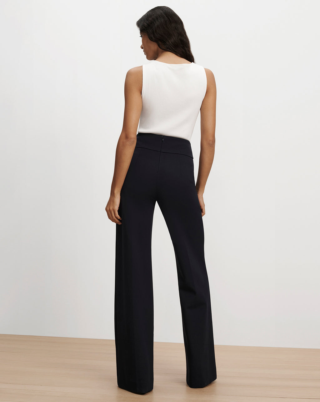 Veronica Beard White sleeveless top and black wide-leg trousers.
