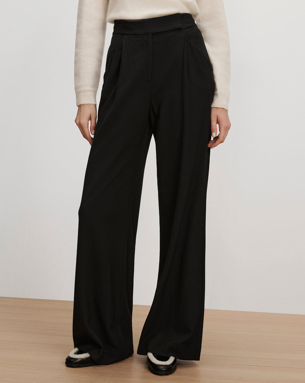 Veronica Beard Black high-waisted wide-leg pleated trousers.