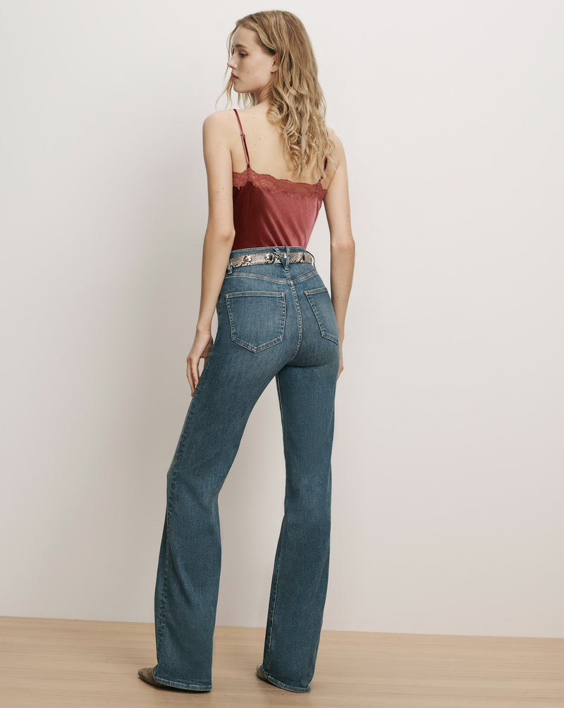Veronica Beard Burgundy lace camisole and blue flare jeans.