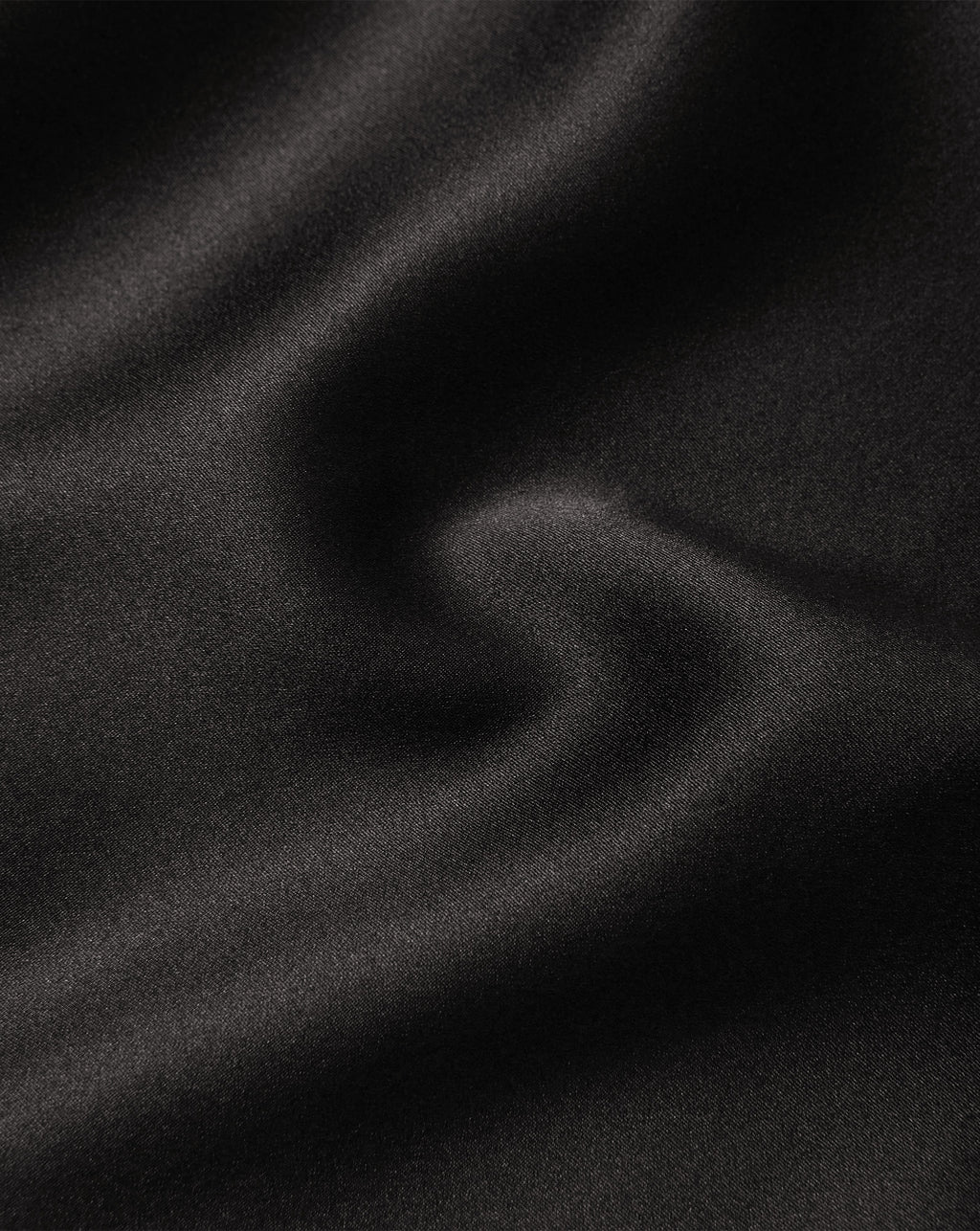 Veronica Beard Black satin fabric with smooth, wavy texture.