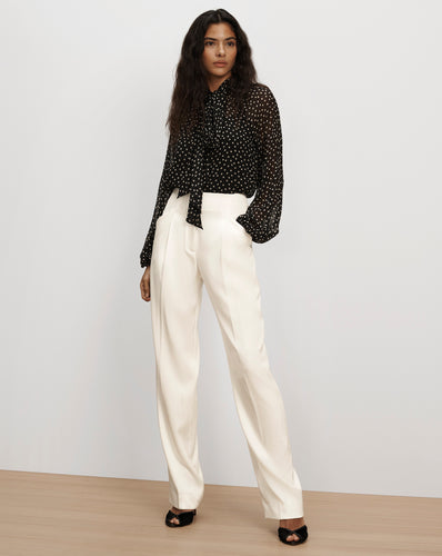 Veronica Beard Black polka dot pussybow blouse and white trousers.
