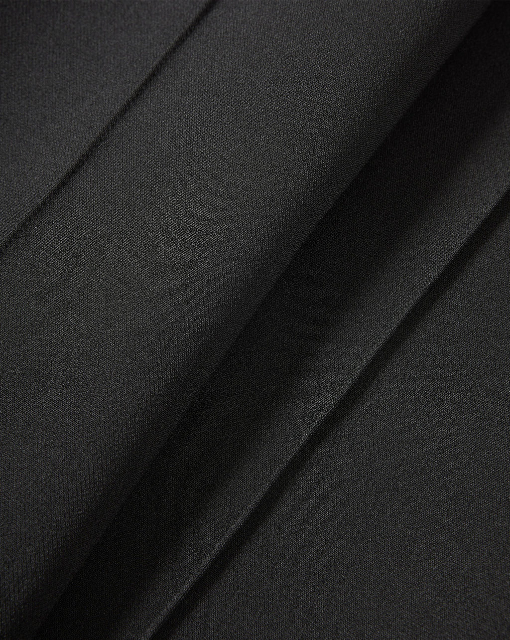 Veronica Beard Black pleated trousers fabric close-up.