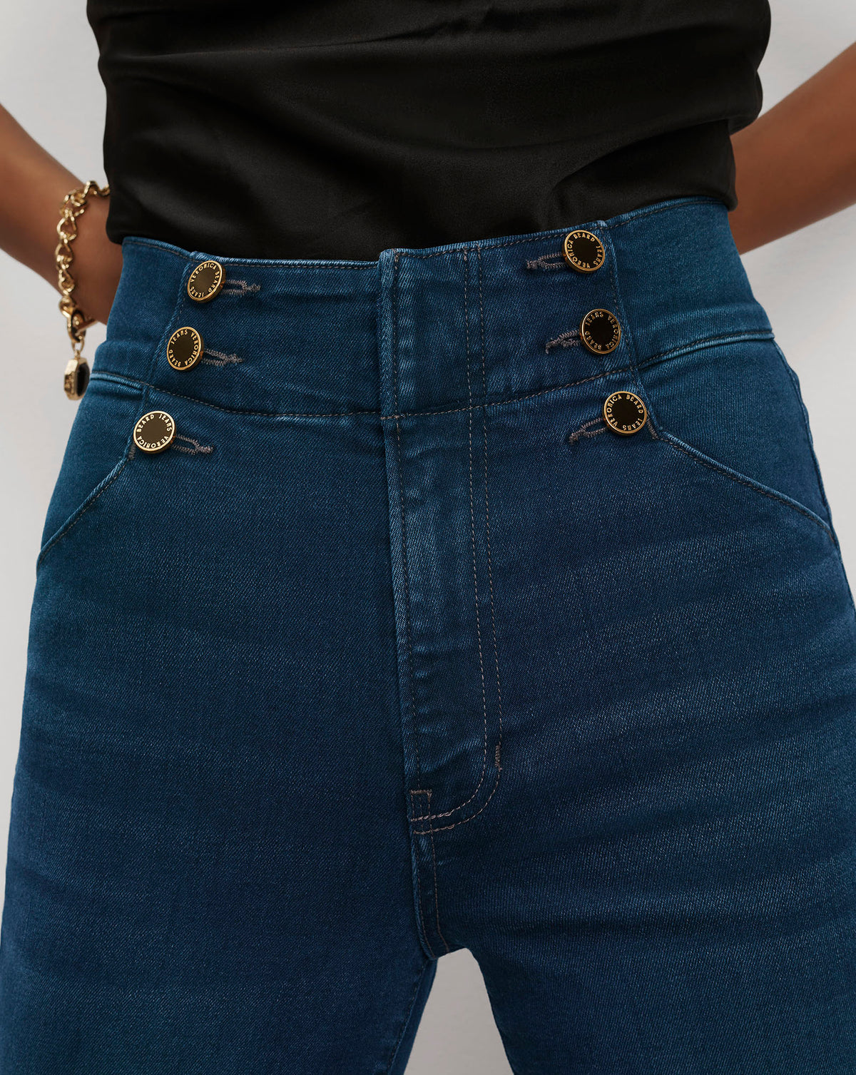 Veronica Beard Blue high-waisted denim pants with gold button details.