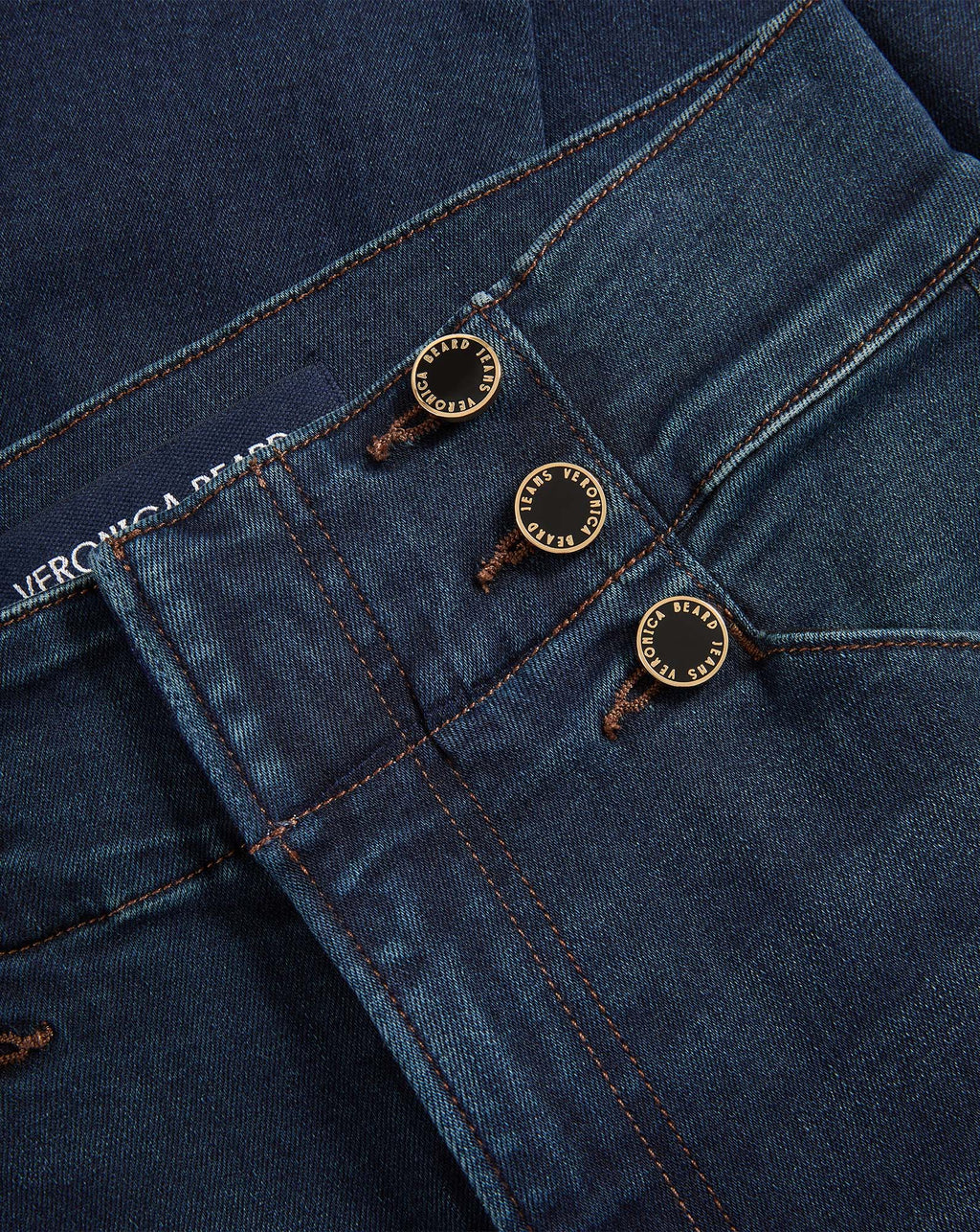 Veronica Beard Dark blue denim jeans with three gold buttons.