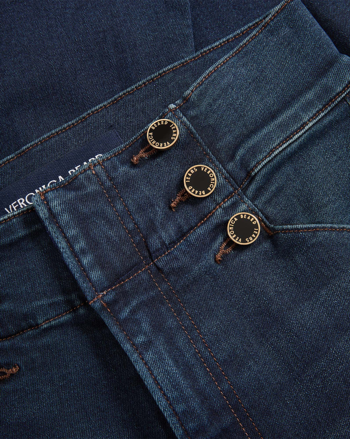 Veronica Beard Dark blue denim jeans with three gold buttons.