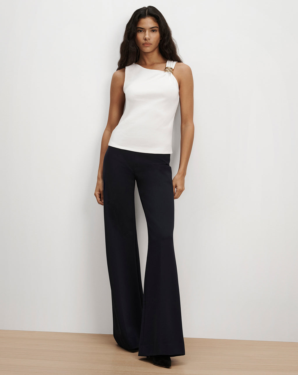 Veronica Beard White asymmetric sleeveless top and black trousers.