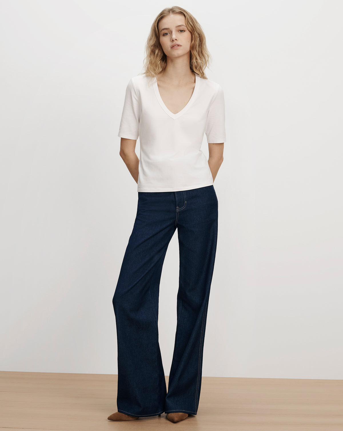 Veronica Beard White v-neck t-shirt and dark blue jeans.