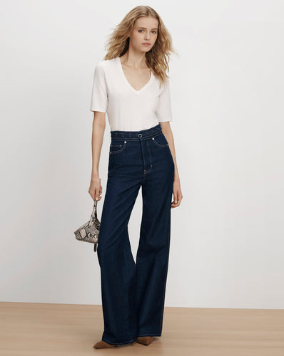 Veronica Beard White v-neck t-shirt and dark flare jeans.