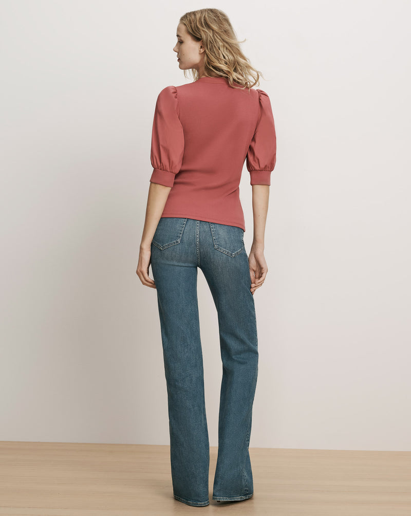 Veronica Beard Pink puff-sleeve top and blue denim jeans.