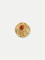 Veronica Beard Textured gold round brooch with red stone.