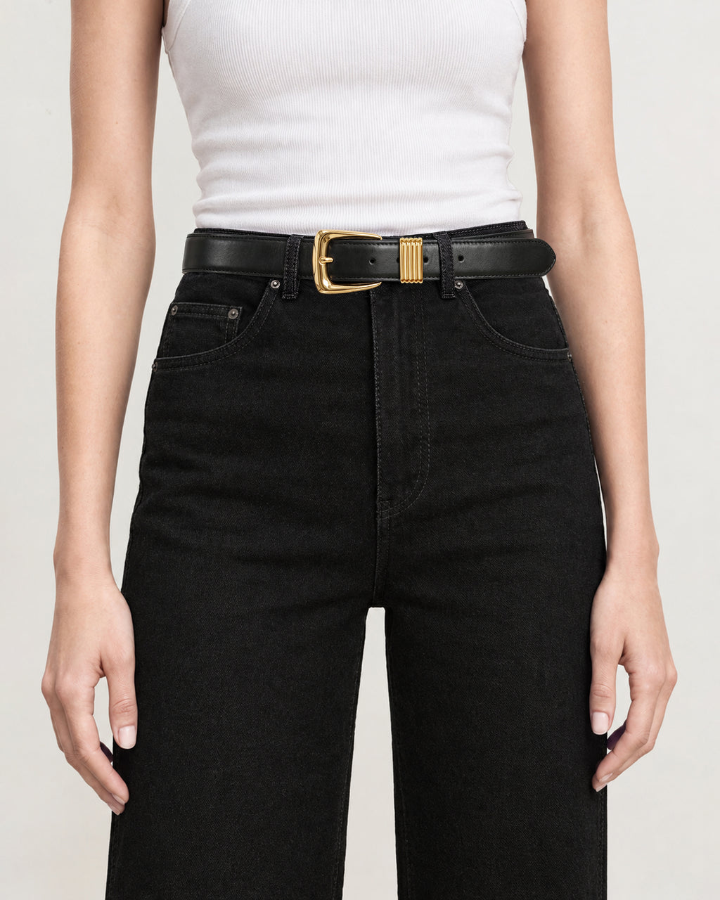 Veronica Beard Black jeans, white tank top, gold-buckled belt.