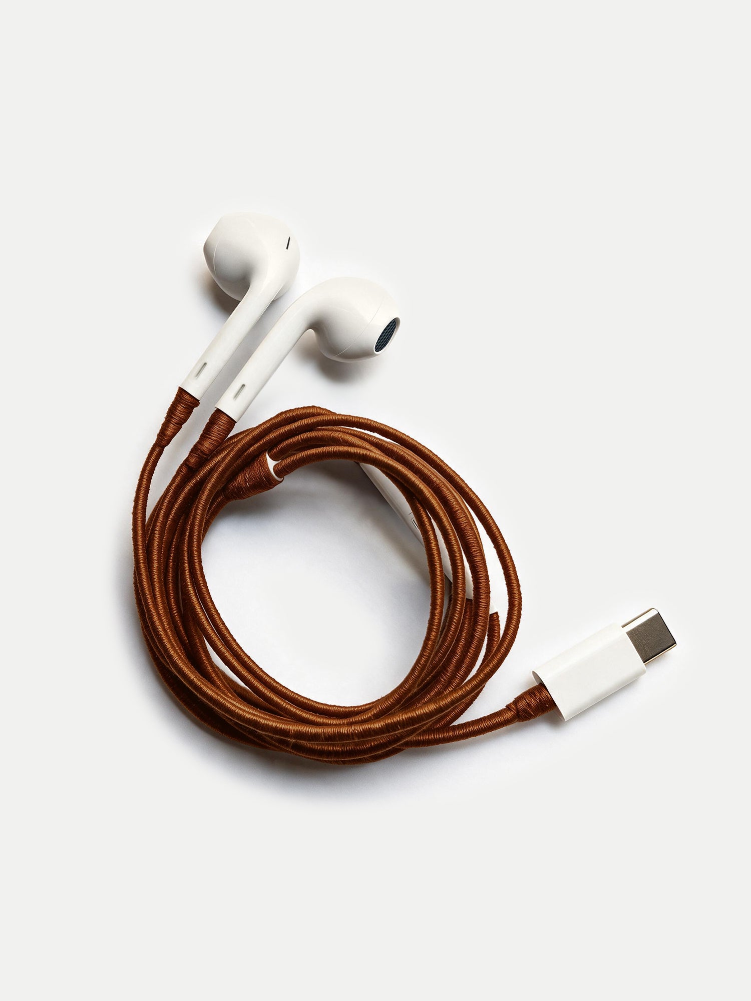 Veronica Beard White earbuds with a coiled brown braided cord and USB-C connector.