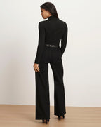 Veronica Beard Black long-sleeve turtleneck top and black wide-leg jeans.