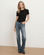 Veronica Beard Black ribbed short-sleeve t-shirt and blue wide-leg jeans.