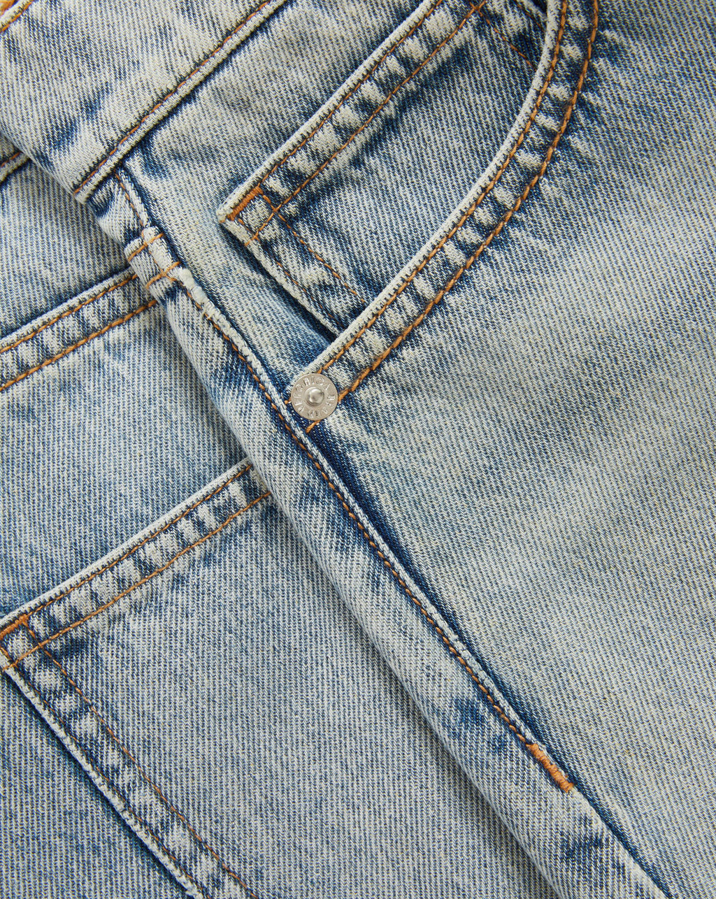 Veronica Beard Peach textured knit cardigan with short sleeves and light wash denim shorts.