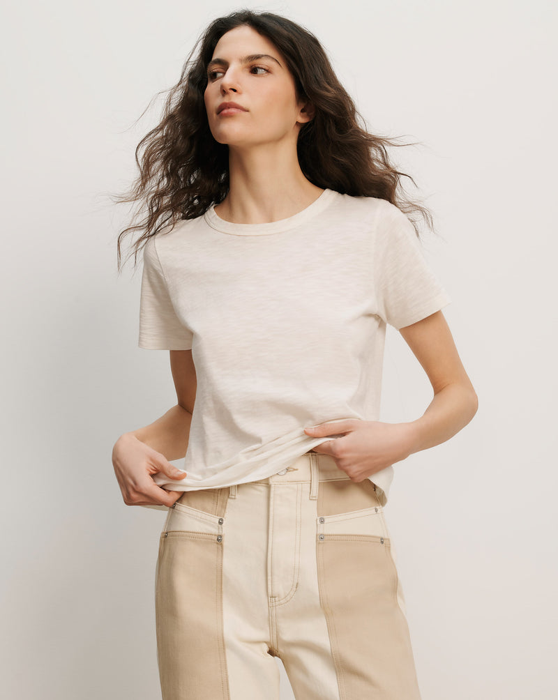 Veronica Beard Cream short-sleeve crewneck t-shirt and two-tone beige and cream high-waisted jeans.